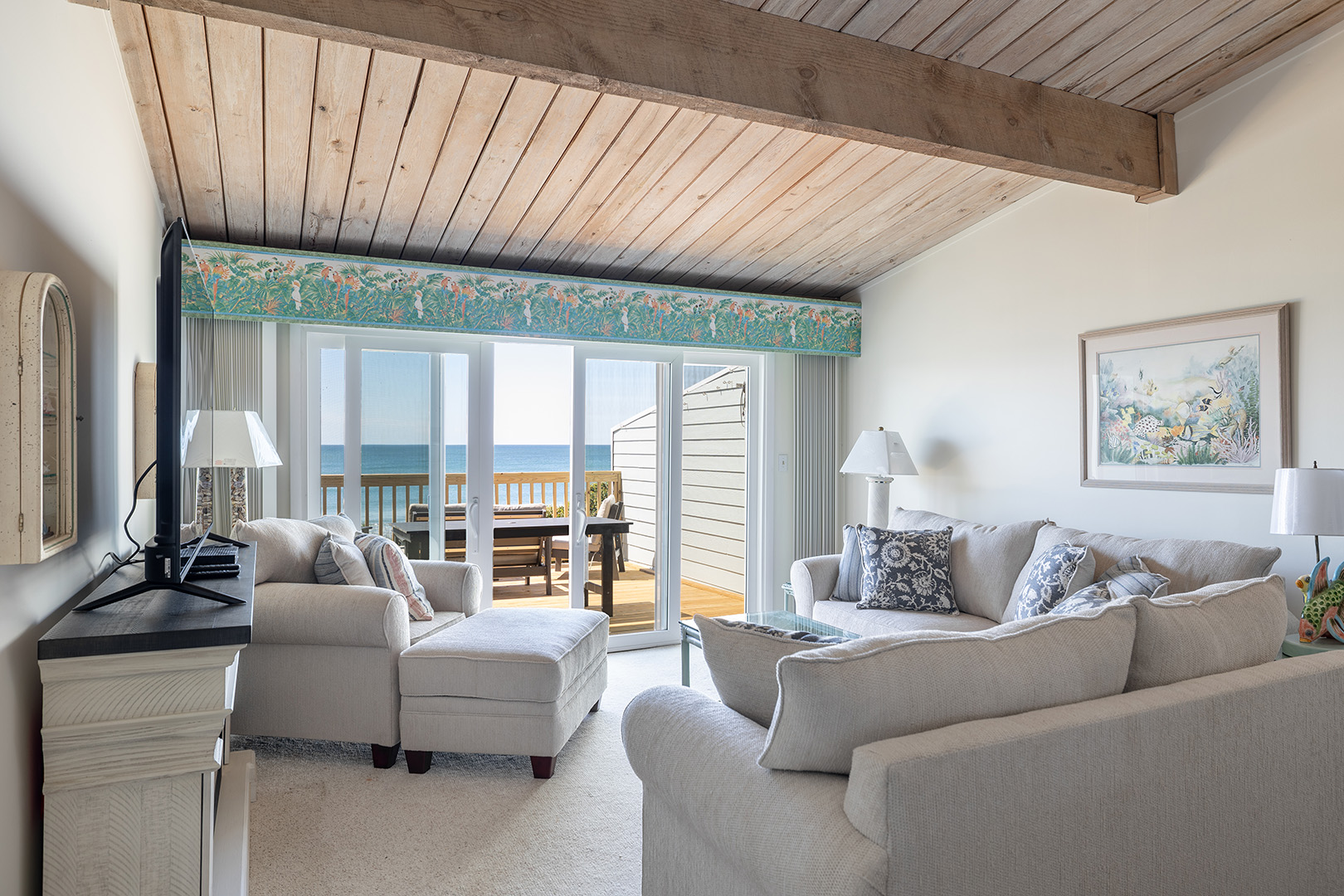 Living room with vaulted wood ceiling and ocean view at Coral Shores 12