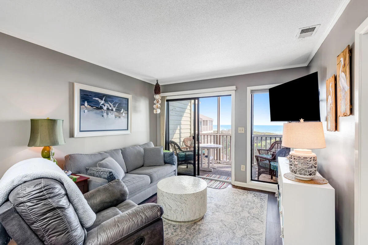 Living room with sliding doors to the oceanfront balcony at Island Beach & Racquet Club B302